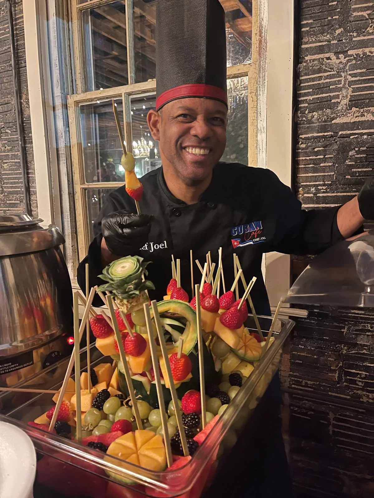 Chef Joel with a carved fruit and skewer display at a company holiday party