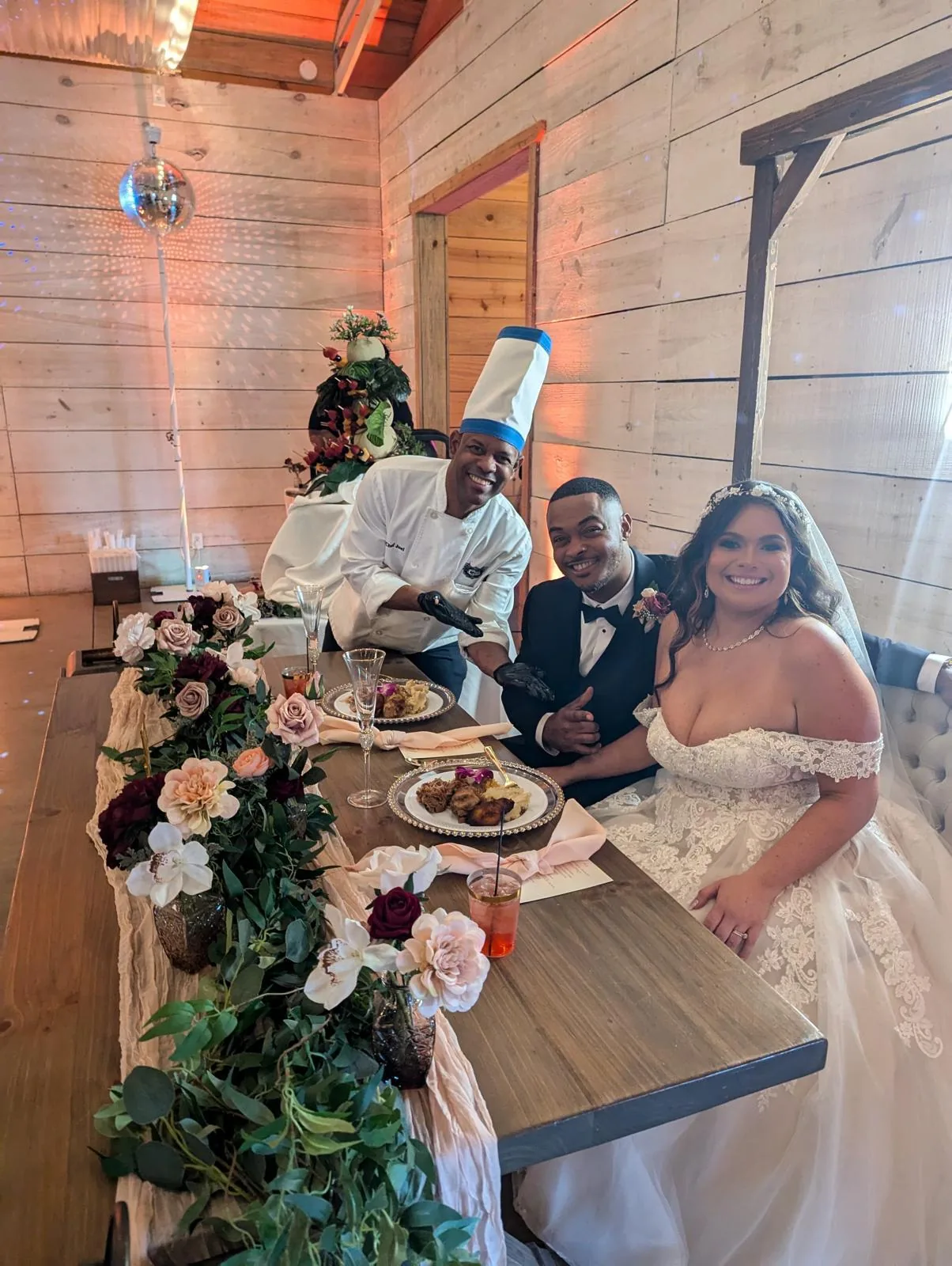 A bride and groom at their floral-decorated head table