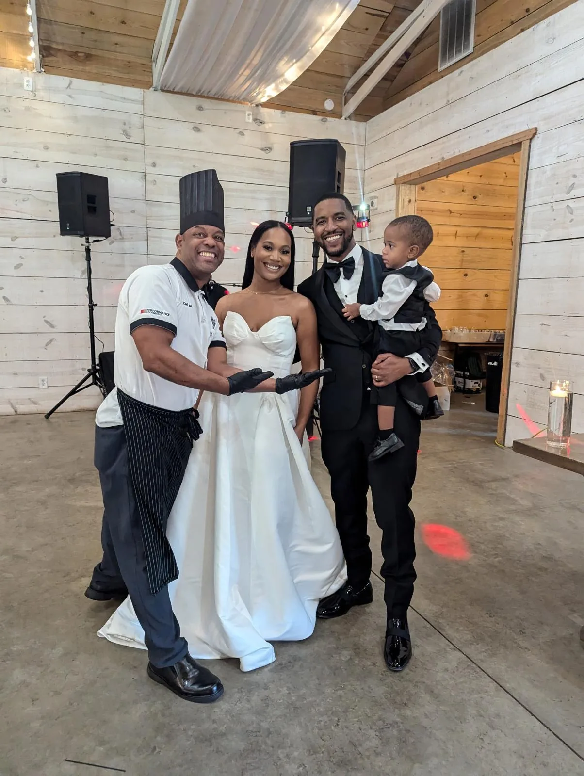 Chef Joel with newlyweds and their little one at the reception