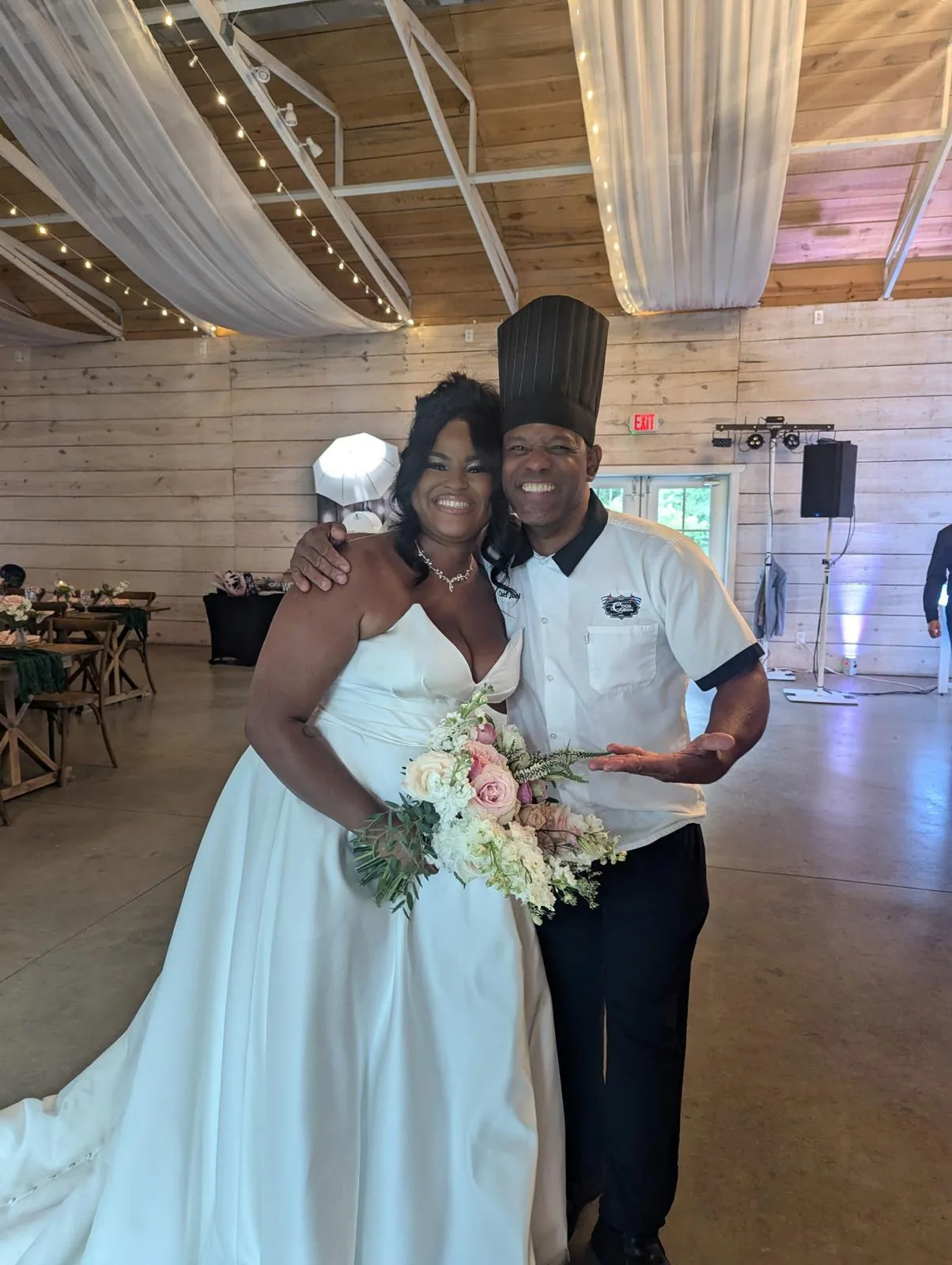 Chef Joel with a bride under warm string lights